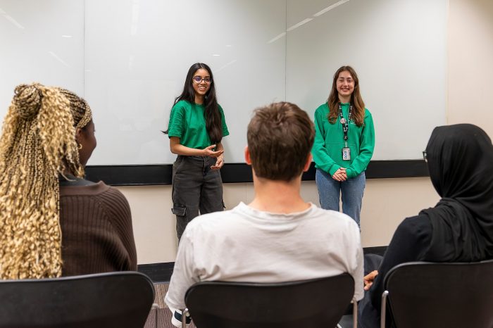  Two Library Peer Mentors hosting a session in front of other students.