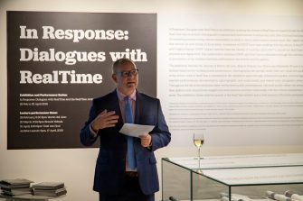Martin Borchert speaking in front of exhibition installation title text
