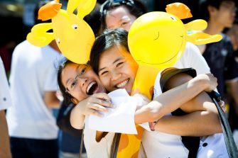 Happy students hugging and holding giraffe ballons - Orientation Week, c. 2011