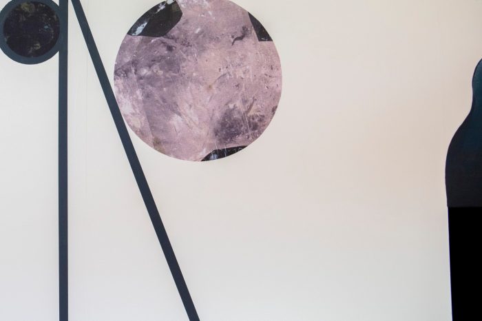 A detail view of an abstract mural comprised of black lines and textured wall decals