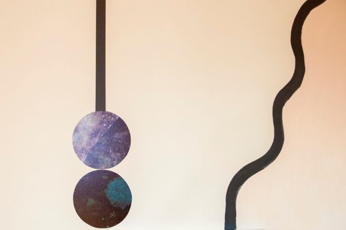 A detail view of an abstract mural comprised of curving lines and textured wall decals