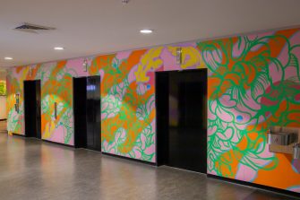 A multicoloured abstract mural surrounding elevator lifts