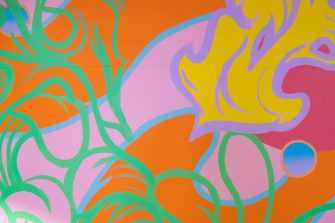 A multicoloured abstract mural comprised of yellow, pink, green, orange, and blue pigments