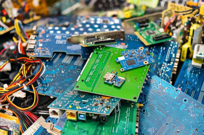 A jumble of discarded circuit boards and electronic components, revealing the raw materials of technology