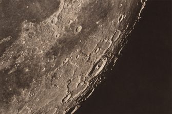 A black and white photographic close up of the moons surface