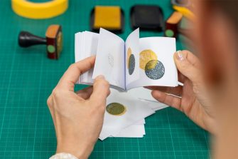 A celestial flipbook created by artist Lisa Sammut with stamped images representing planets.