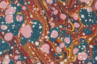 A turkish-style marbling pattern on paper, featuring striking pink droplets on a backdrop of swirling sky blue, orange, and red colours. 
