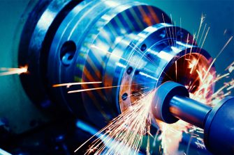 Close of up machinery grinding, sparks are visible.