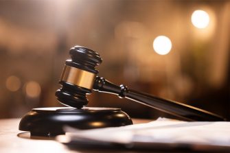Close up of a black and gold judge's gavel and sound block.