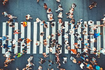 A bird's eye view of a pedestrian crossing with pedestrians walking across in both directions.