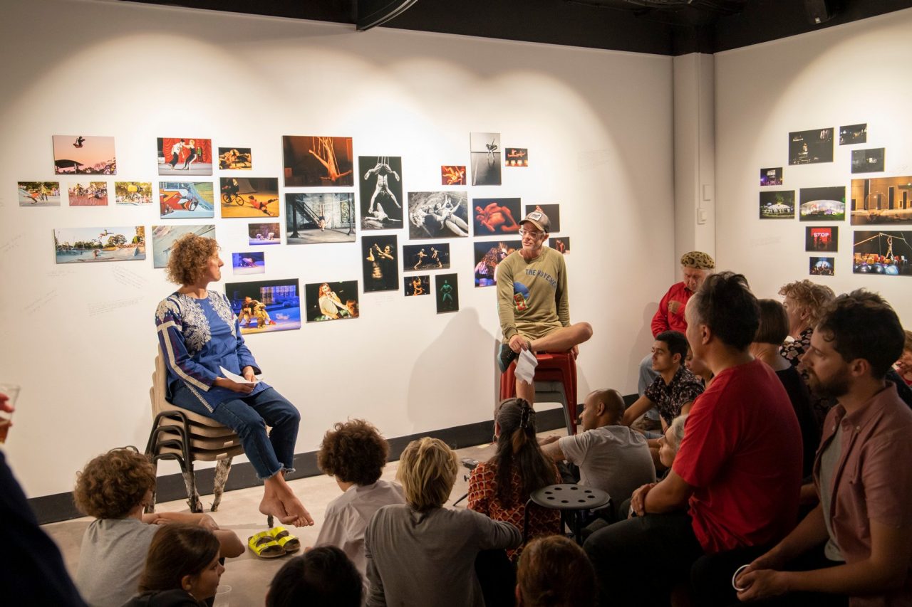 Branch Nebula - Crowd watching performers sitting in stacked chairs