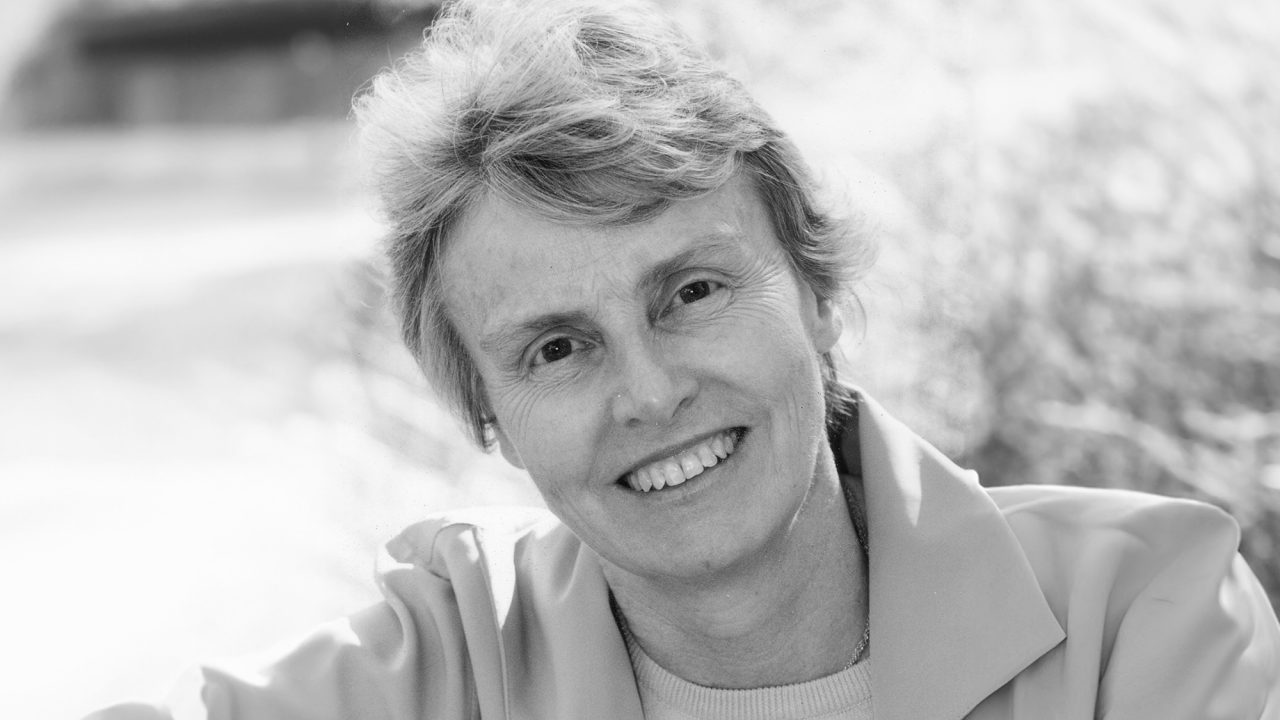 Black and white photo of a lady smiling at the camera