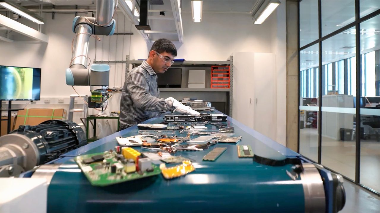 A person working in the MICROfactorie sorting through items on a convoyer belt.