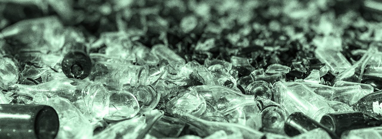 Numerous pieces of broken glass of varying sizes and shapes, seen at close range in shades of green.