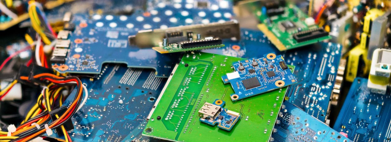 A jumble of discarded circuit boards and electronic components, revealing the raw materials of technology