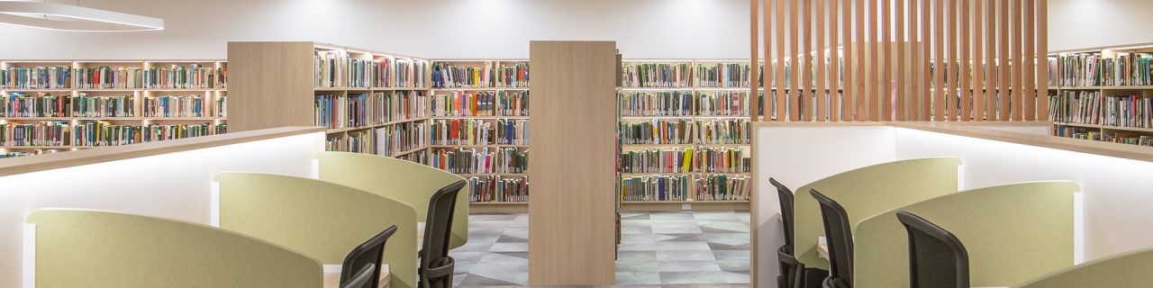 2 rows single partitioned study desks with print collection shelves in background